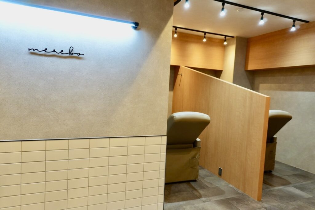 ME.REBO池袋D/O店の店内写真。白タイルとミラーが印象的な、洗練されたサロン空間。