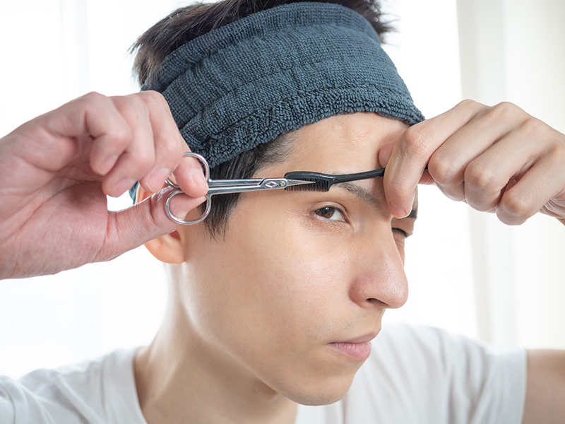 自分で眉カットをする男性