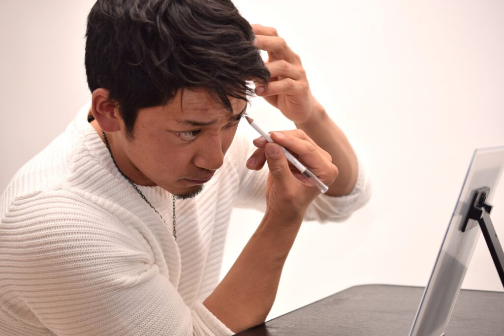 眉メイクする男性