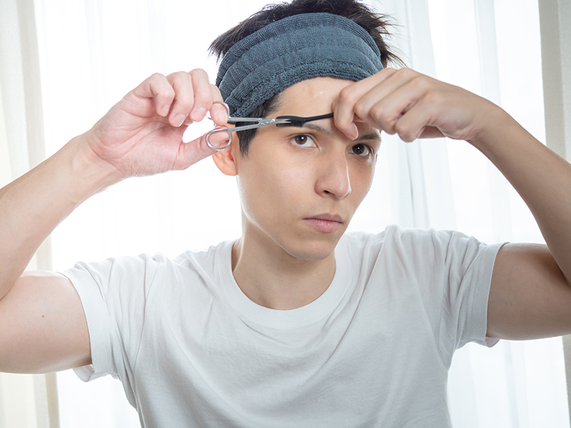 自分で眉カットをする男性
