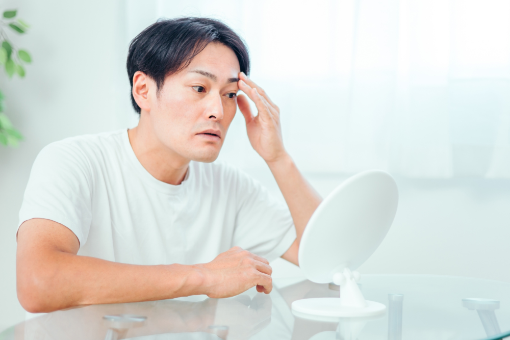 濃い眉毛を整えるのに失敗して落ち込む男性