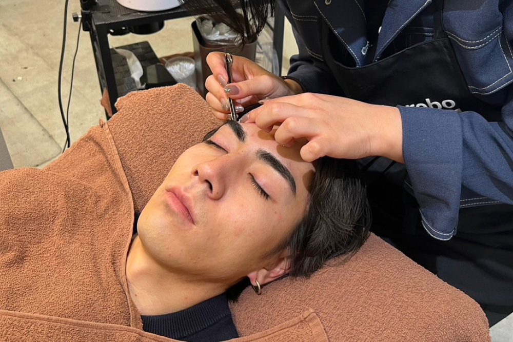 メンズ専門の眉毛サロンで施術を受ける男性