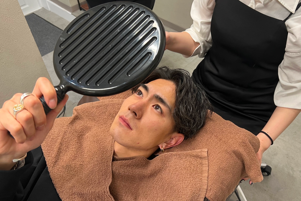 眉毛サロンで仕上がりのイメージをチェックする男性